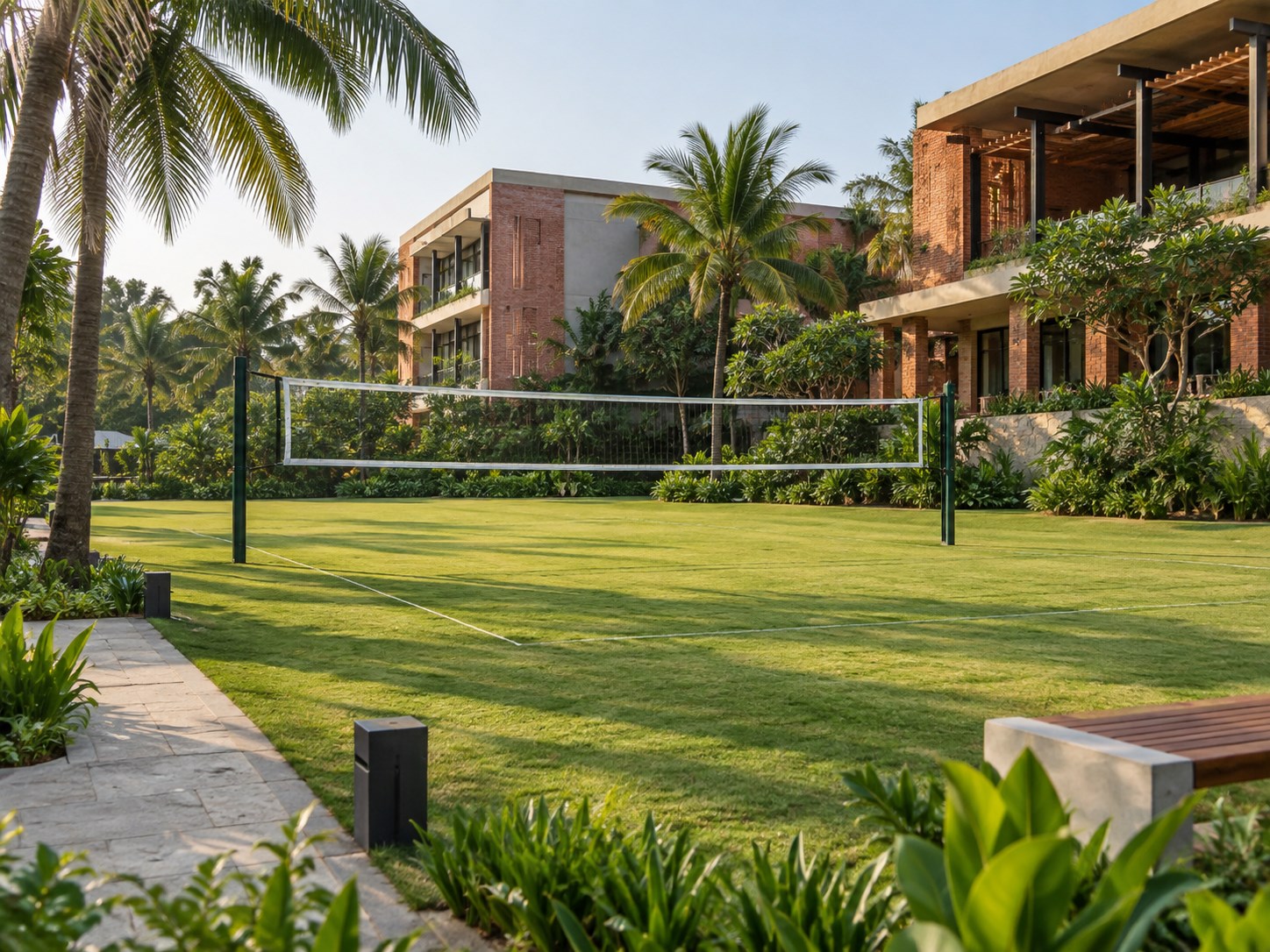 wide sunlit green recreation lawn with simple volleyball net, palms and landscaped paths, contemporary concrete and brick resort beyond